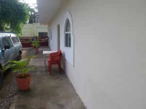 Little patio area with a table and chairs.. Aire de patio avec table et chaises.