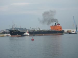 Big boat, with a little tug boat beside and behind it.