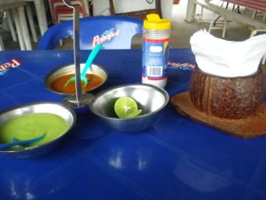 Mexican condiments: salt, lime, hot sauce, and guacamole (a very thin avocado-based sauce).